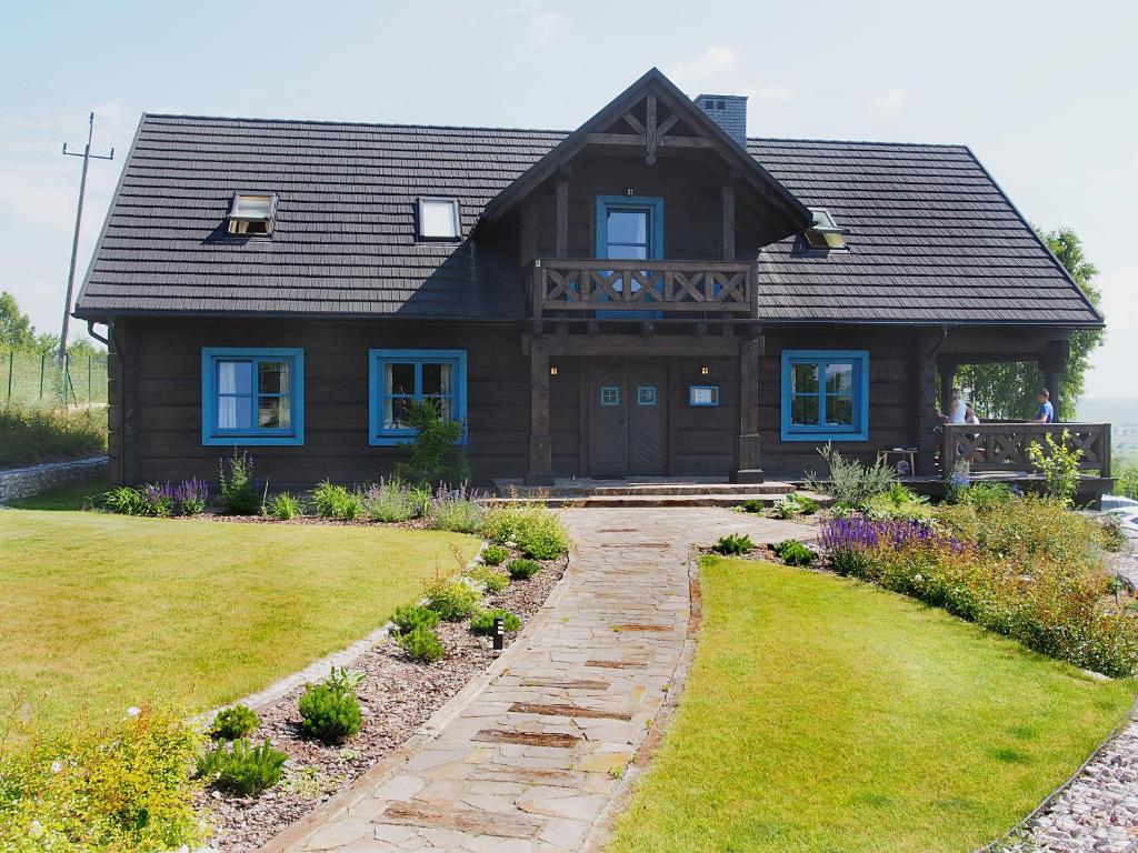 a large wooden house with a pathway in front of it at Świetnokrzyska Chata in Bodzentyn