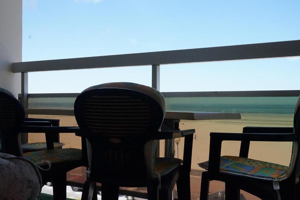 a group of chairs sitting in front of a window at Le Grand Large in Berck-sur-Mer