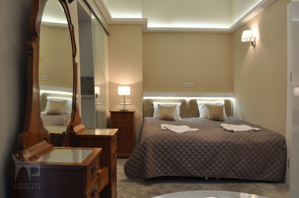 pokój hotelowy z łóżkiem i lustrem w obiekcie Apartamenty Podwale w Krakowie