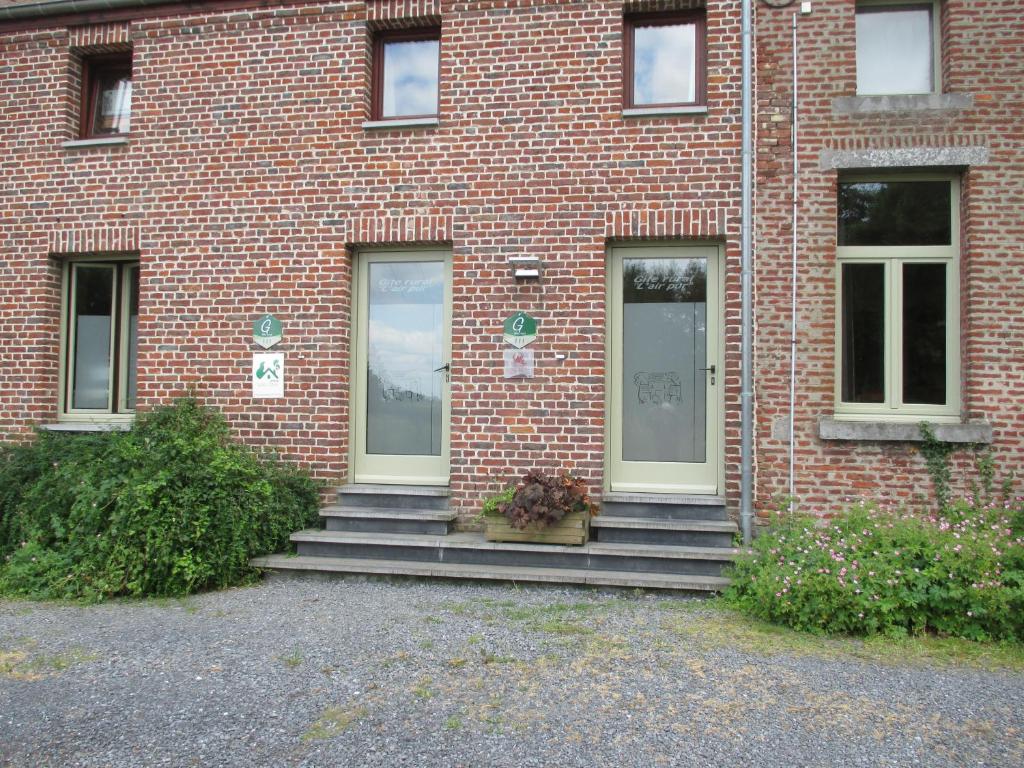 a brick building with stairs in front of it at Gîte L'air pur in Roisin