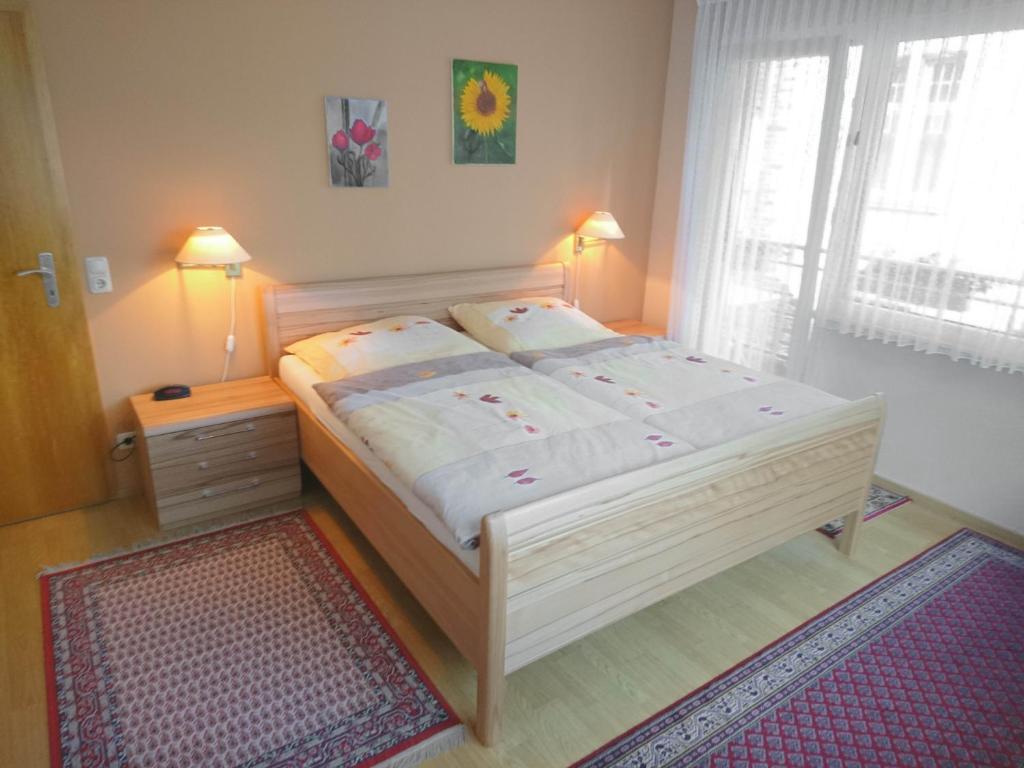 una camera con un letto bianco, un tappeto e una finestra di FeWo Ingrid Trossen a Ürzig