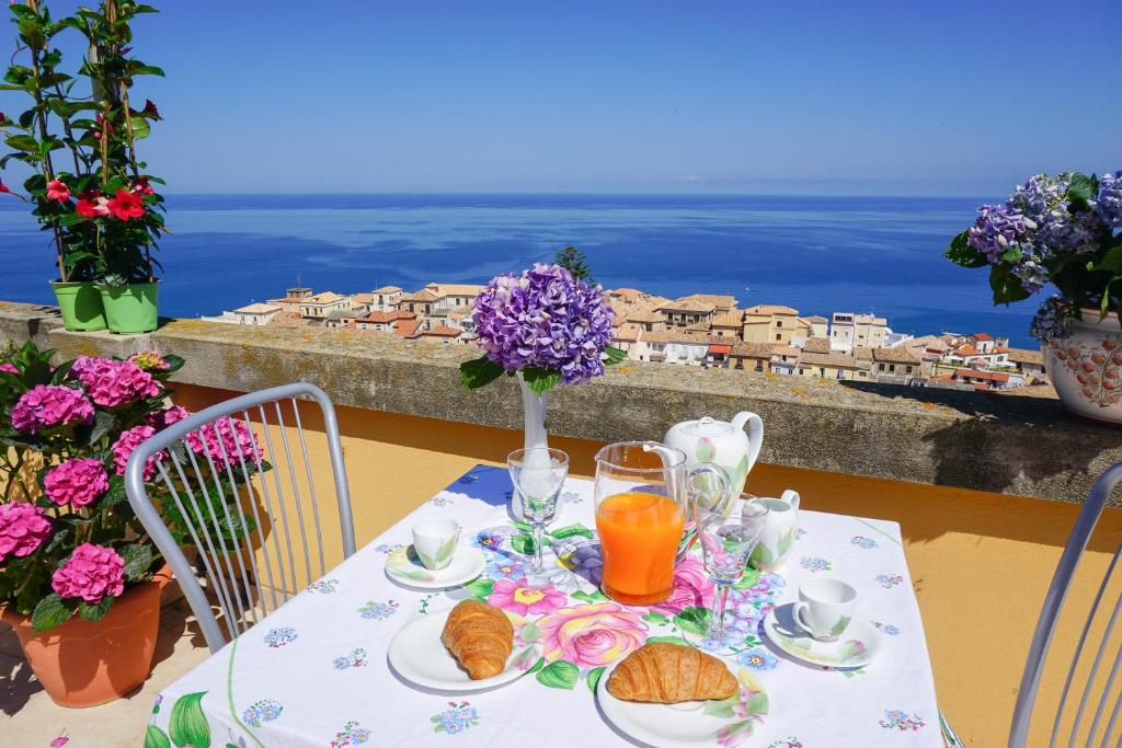 einen Tisch mit einem Teller Essen und Meerblick in der Unterkunft Il Terrazzo su Pizzo in Pizzo