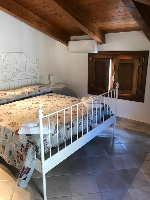 sypialnia z białym łóżkiem i drewnianym sufitem w obiekcie Casa Vacanze Primula palinuri w mieście Futani