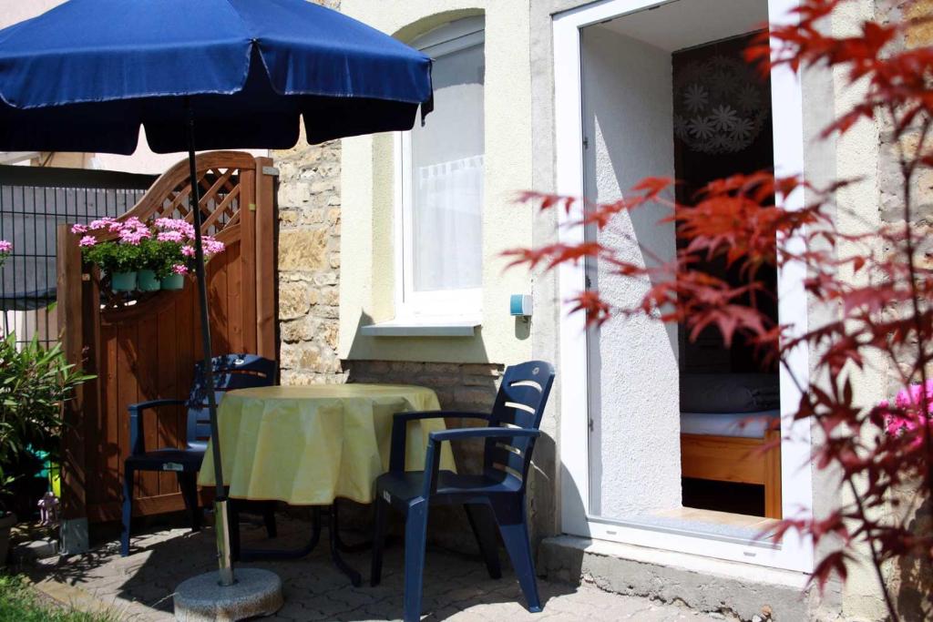 - une table, des chaises et un parasol sur la terrasse dans l'établissement Ferienwohnung Gessert, à Querfurt