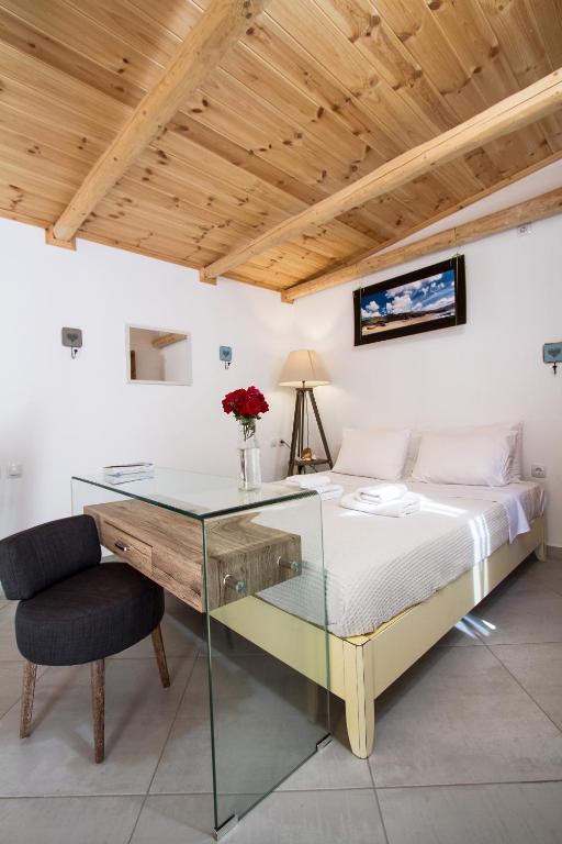 sypialnia ze szklanym biurkiem i łóżkiem w obiekcie Mera Beachfront House - Falasarna w mieście Falasarna