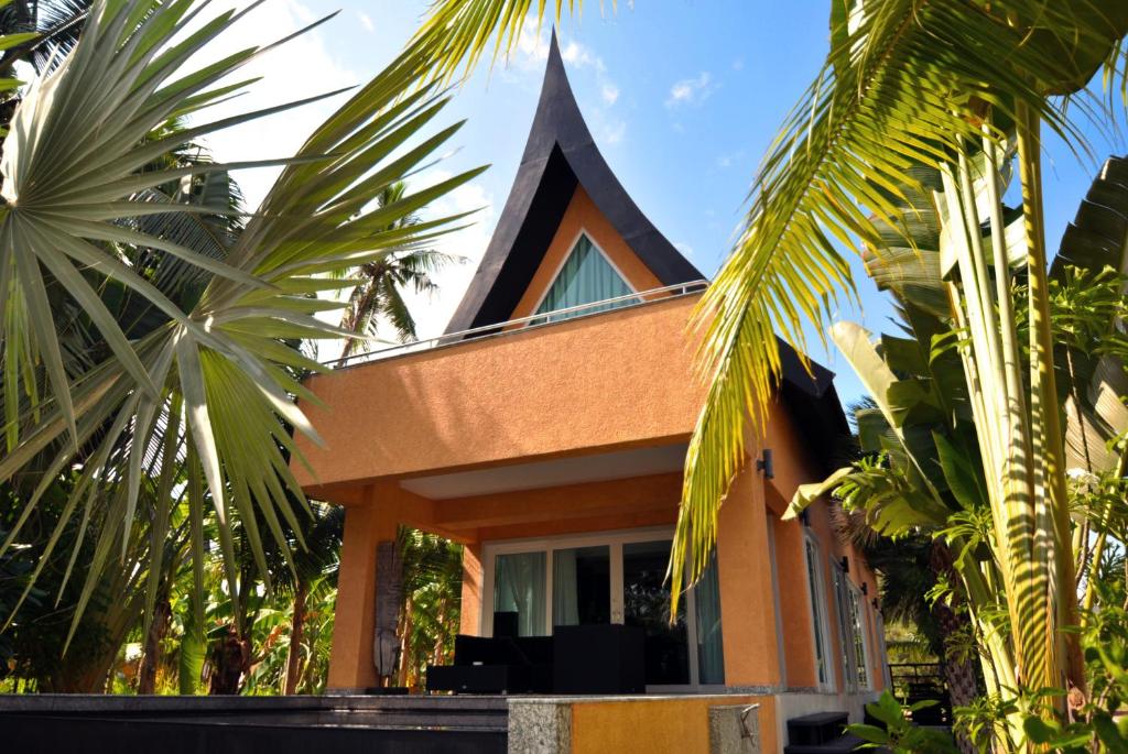 象島的住宿－白龍海景別墅，一座有尖顶和棕榈树的房子