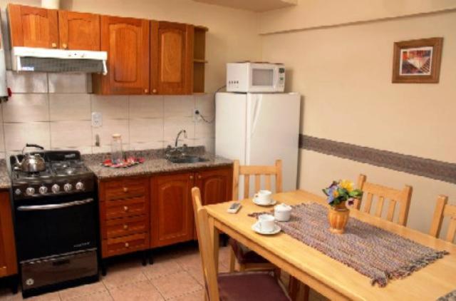 cocina con mesa y cocina con nevera en Departamento Centrico en Mendoza