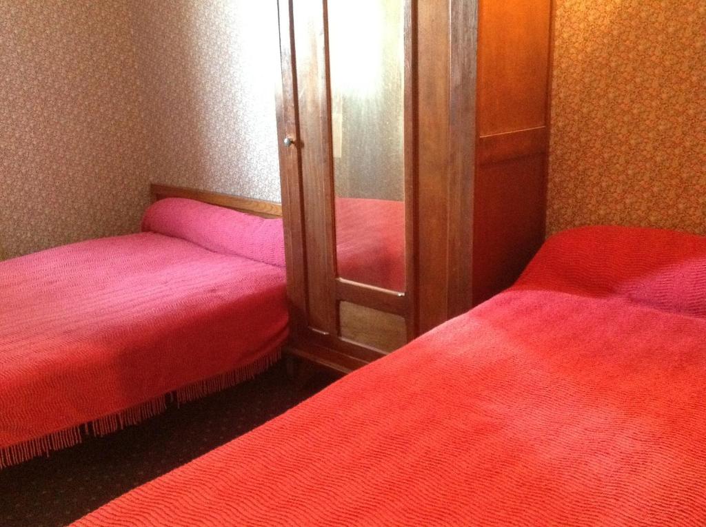 a small room with two beds and a mirror at Maison Notre Dame de la Treille in Lourdes