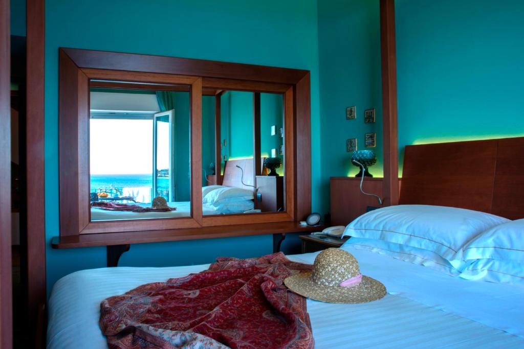 a bedroom with a bed with a hat on it at Hotel Palladio in Giardini Naxos