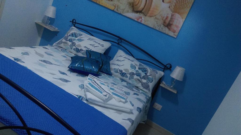 ポルトパーロにあるB&B Stella Marinaの青い壁のベッド付きの青いベッドルーム1室