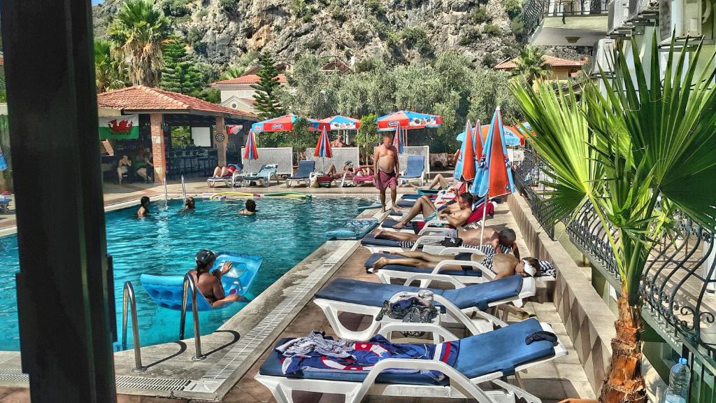 オルデニズにあるTaner Otelのリゾートのプールで横たわっている人々のグループ