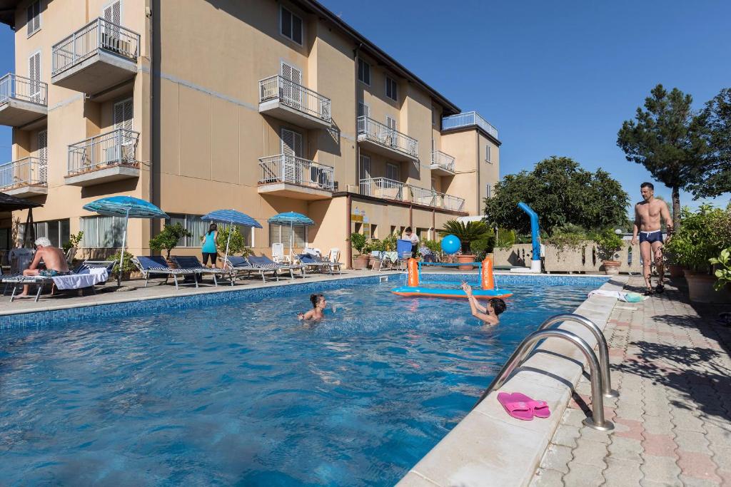Hotel Darsena في باسّينيانو سول ترازيمنتو: مجموعة أشخاص في مسبح في فندق