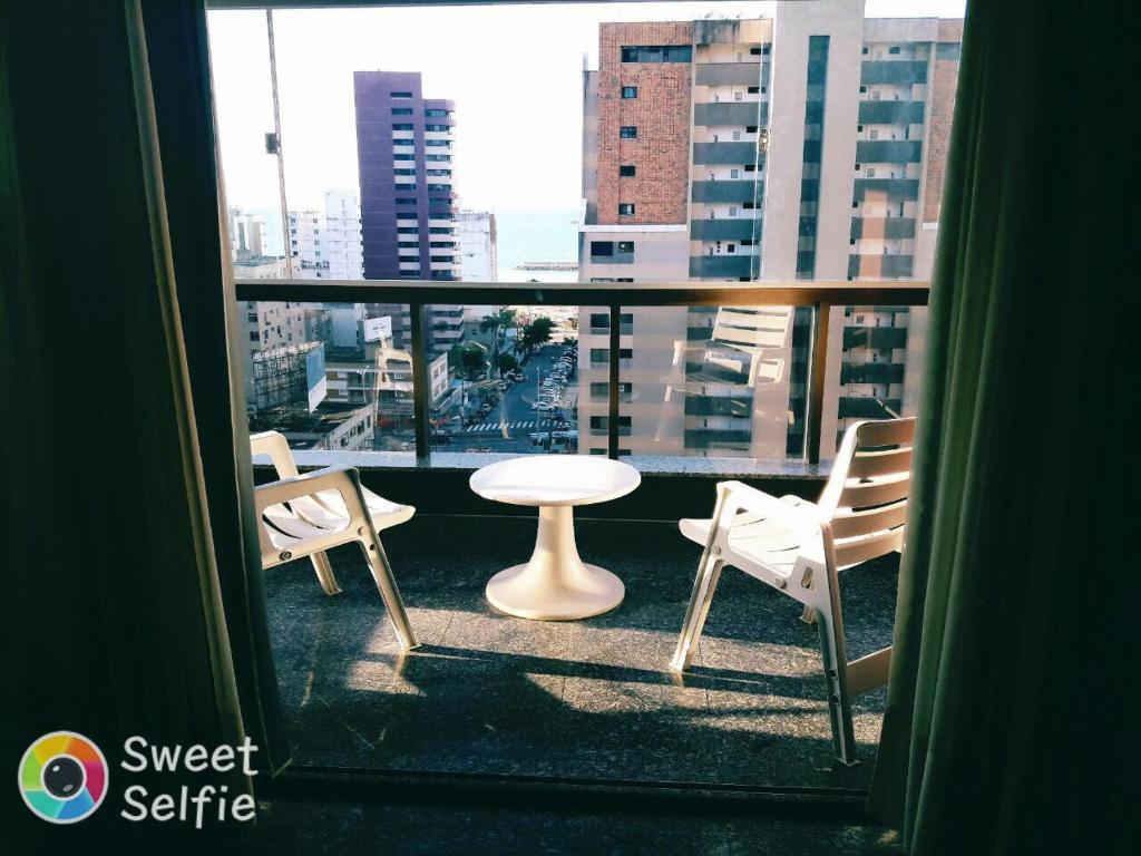 Habitación con vistas a un balcón con mesa y sillas. en Flat Luzon, en Fortaleza