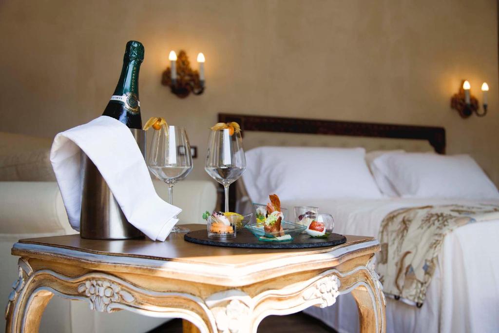 a table with a bottle of wine and glasses on a bed at Boutique Hotel Elvezia in Stresa