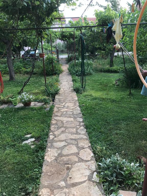 a stone path in a yard with a garden at Green Quiet Apartments in Vodice