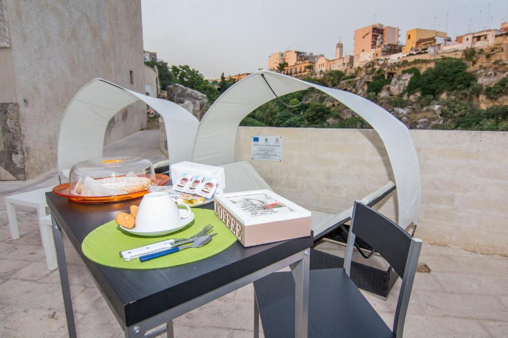 une table avec une assiette de nourriture sur un balcon dans l'établissement Rifugio Massafera, à Massafra