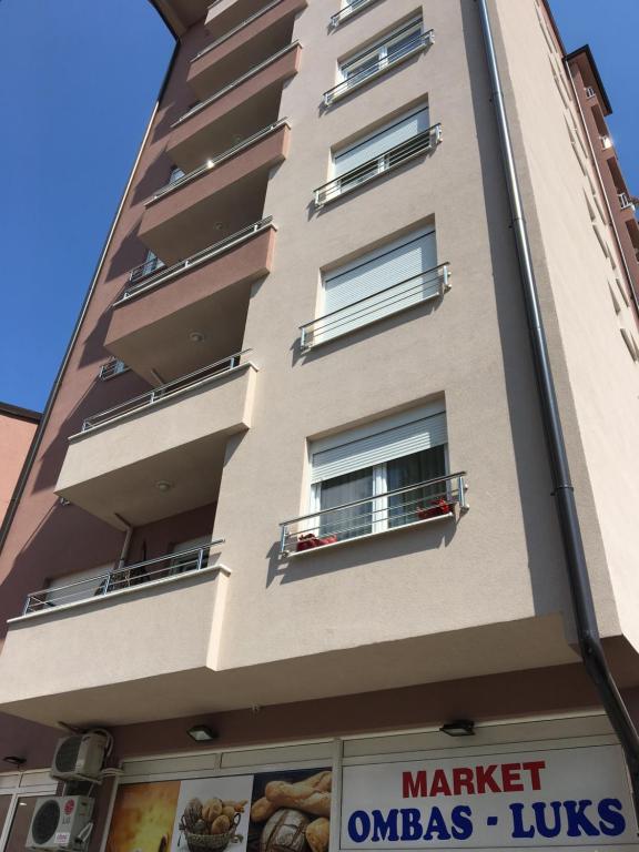 un edificio alto con ventanas y un cartel delante en Apartment Smestaj B, en Novi Pazar