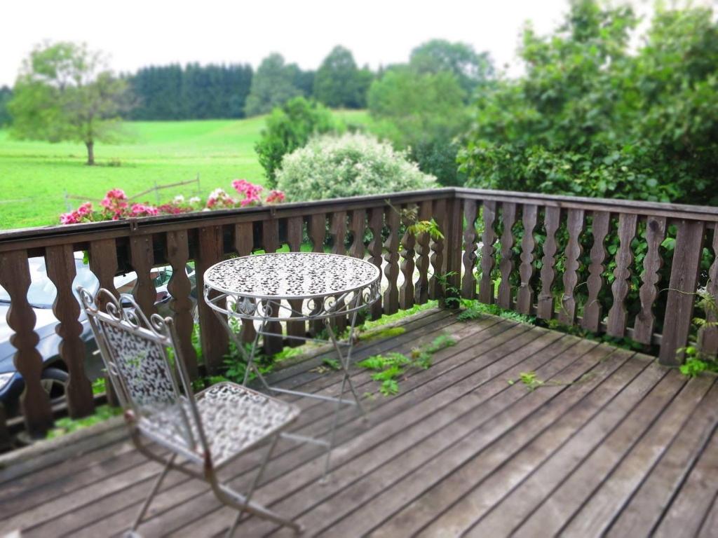einen Tisch und Stühle auf einer Holzterrasse in der Unterkunft Apartment Foelslhof in Siegsdorf