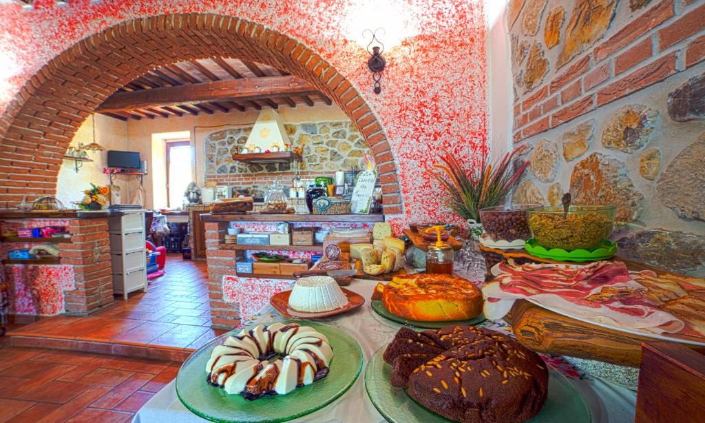 センプロニアーノにあるAgriturismo La Valle degli Uliviのキッチン(様々な種類のケーキを楽しめるテーブル付)