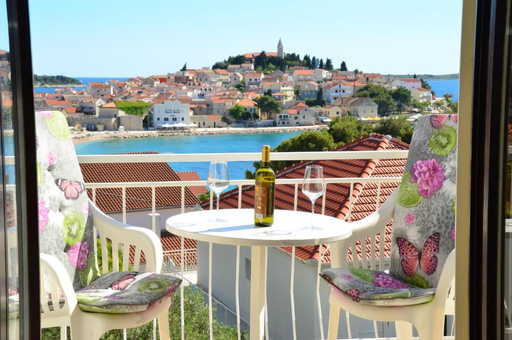 a table with a bottle of wine on a balcony at Apartmani Piculo in Primošten