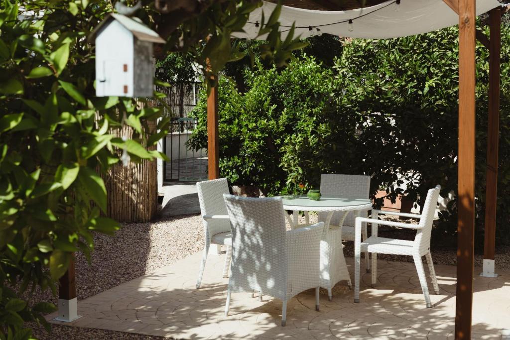 un patio con mesa y sillas y una casa de aves en Apartamentos Casa Torres - Adults Only, en Albir