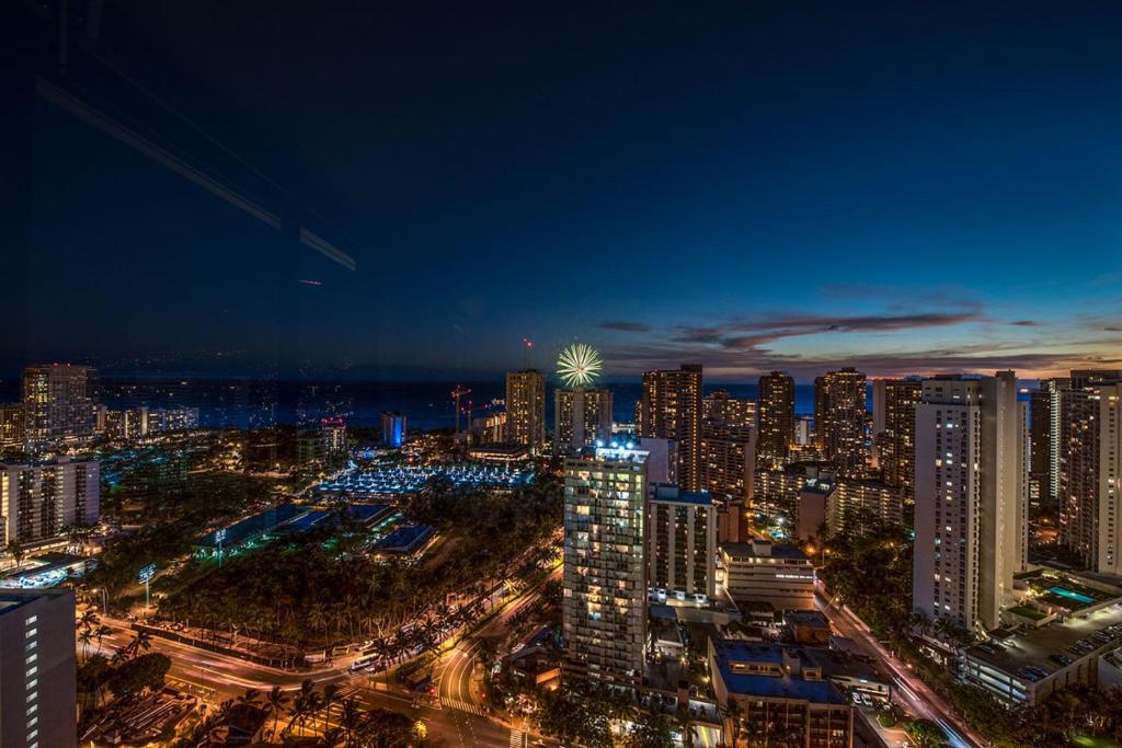 uma cidade iluminada à noite com edifícios em Hawaiian Monarch Penthouse 402 em Honolulu