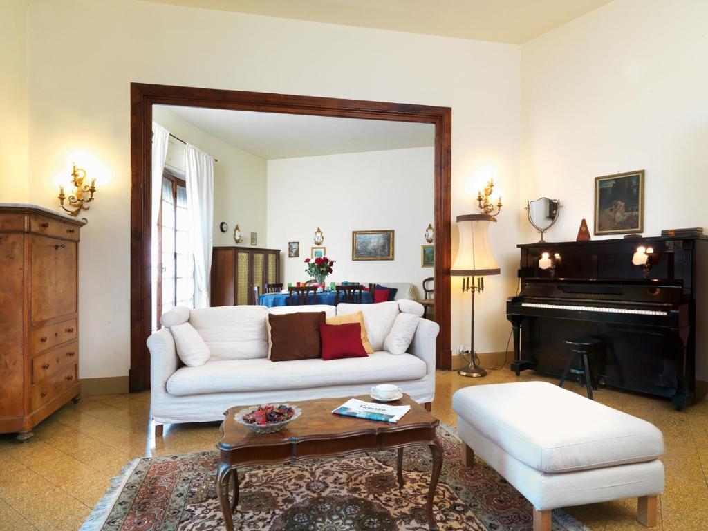 een woonkamer met een witte bank en een piano bij Residenza Oltrarno in Florence