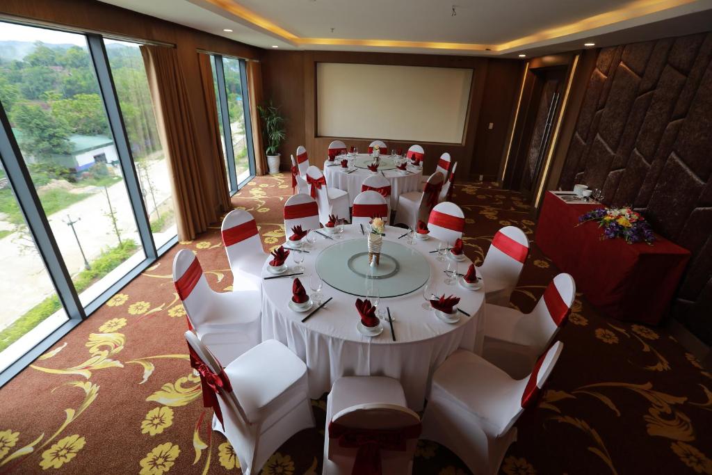 a conference room with a white table and chairs at Muong Thanh Holiday Con Cuong in Con Cuông