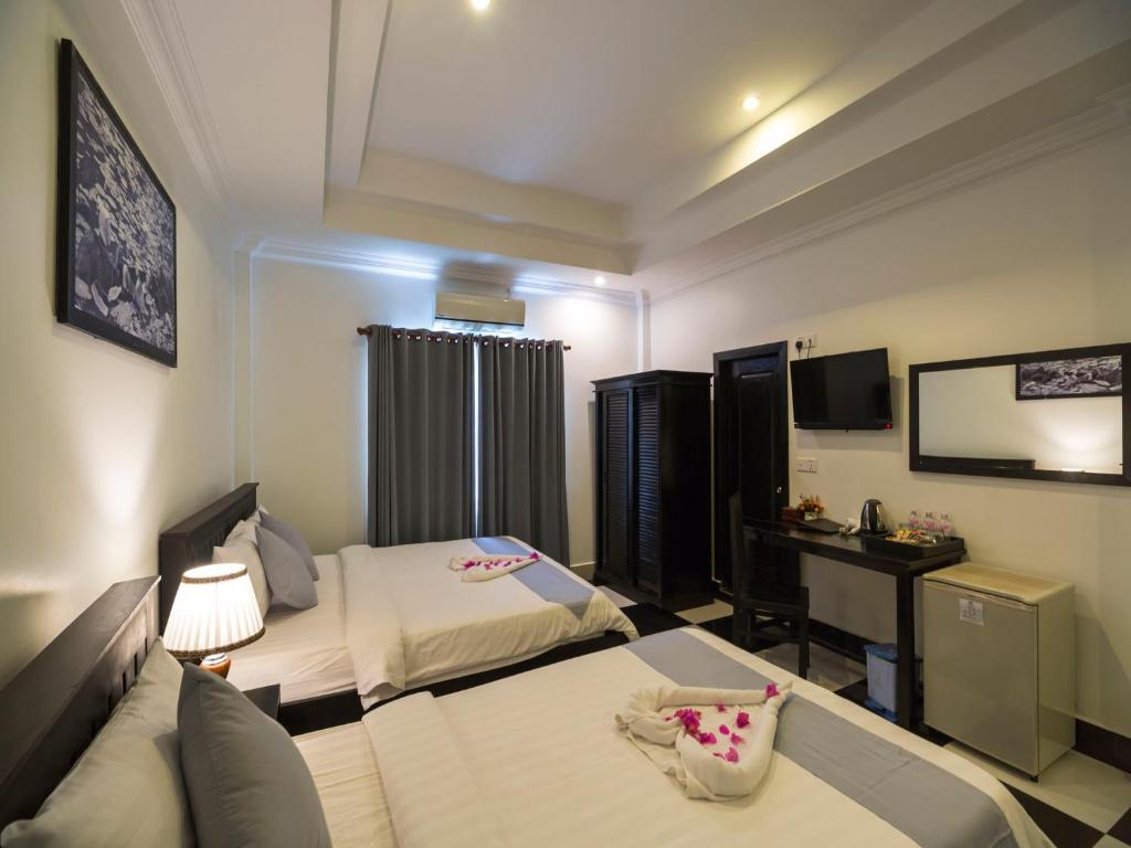Postel nebo postele na pokoji v ubytování Rithy Rine Angkor Residence