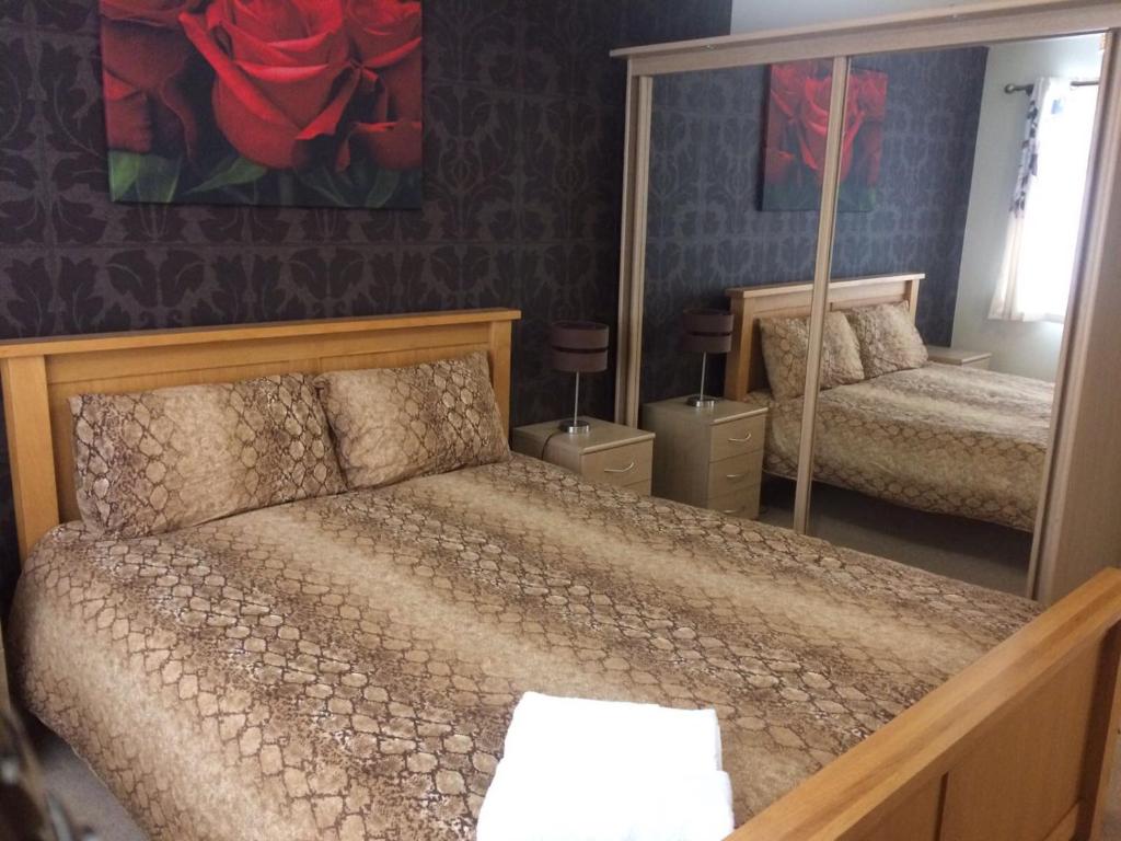 1 dormitorio con cama y espejo en Falconwood Apartment en Mánchester