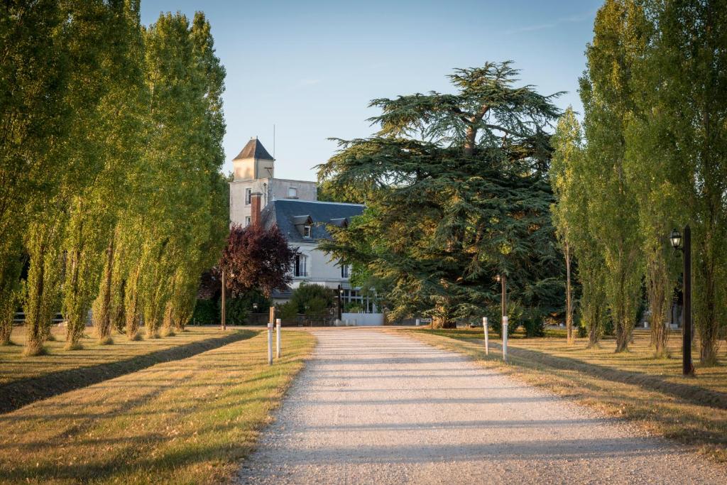 a tree lined road in front of a building at Relais Des Landes in Ouchamps