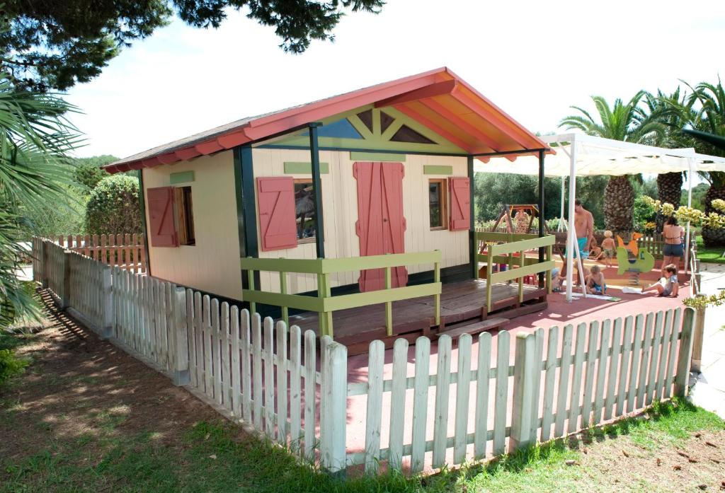 a small house with a fence in a yard at Grupotel Playa Club in Son Xoriguer