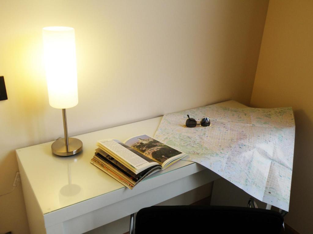 a table with a lamp and a book and a map at Center Gran Via in Barcelona