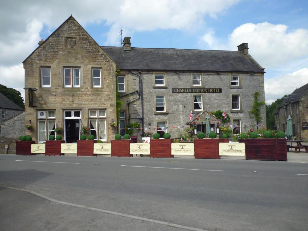 an old stone building on the side of a street at Charles Cotton Hotel in Hartington