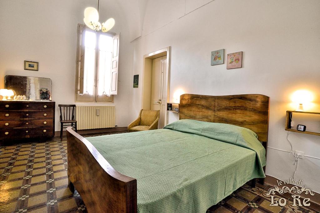 SurboにあるLe Volte di Lo Reのベッドルーム1室(大型ベッド1台、緑の毛布付)