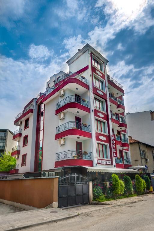 a tall white and red building with balconies at Family Hotel Prestige in Burgas