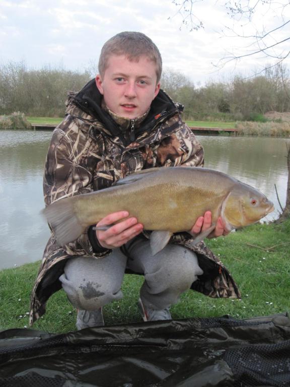 a man holding a fish in front of a body of water at Warrens Village Motel and Self Catering in Clevedon