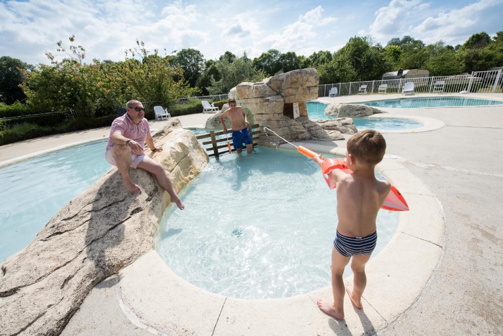 a man and a little boy playing in a swimming pool at Camping Du Port De Plaisance in Péronne