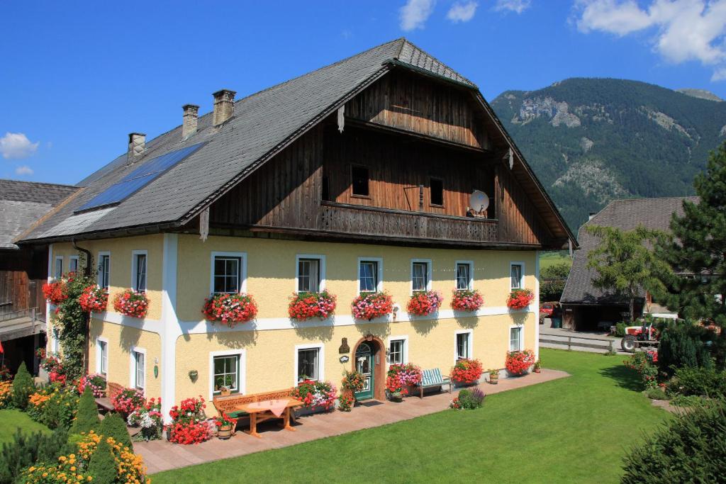 ein großes Haus mit Blumen davor in der Unterkunft Loitzbauer Ferienwohnungen in Sankt Gilgen