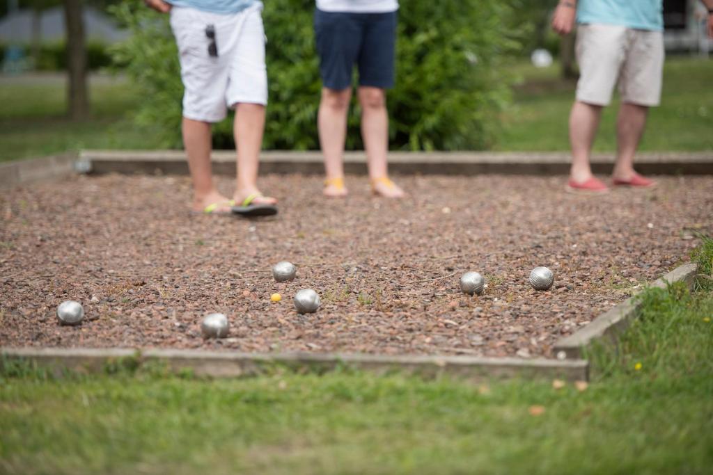 a group of people standing on a golf course at Camping Du Port De Plaisance in Péronne