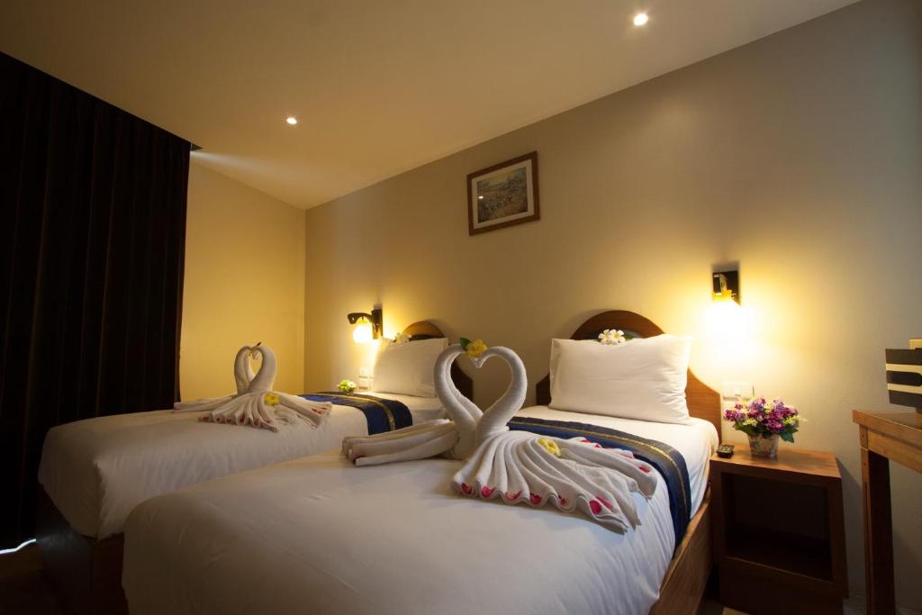 una habitación de hotel con dos cisnes en las camas en At Samui Boutique Hotel, en Chaweng