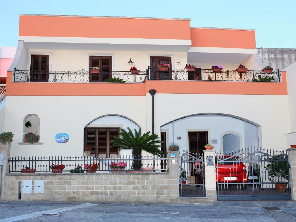 una casa blanca y naranja con una valla en B&B Minerva, en Castro di Lecce