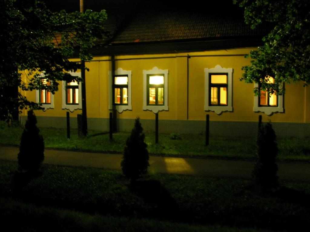 una casa por la noche con luces en las ventanas en Almásliget Vendégház, en Mátramindszent