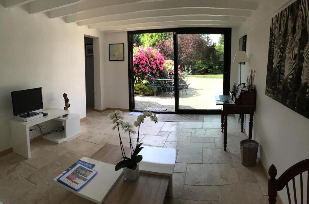 a living room with a view of a garden at Le Clos des Cordeliers in Sézanne