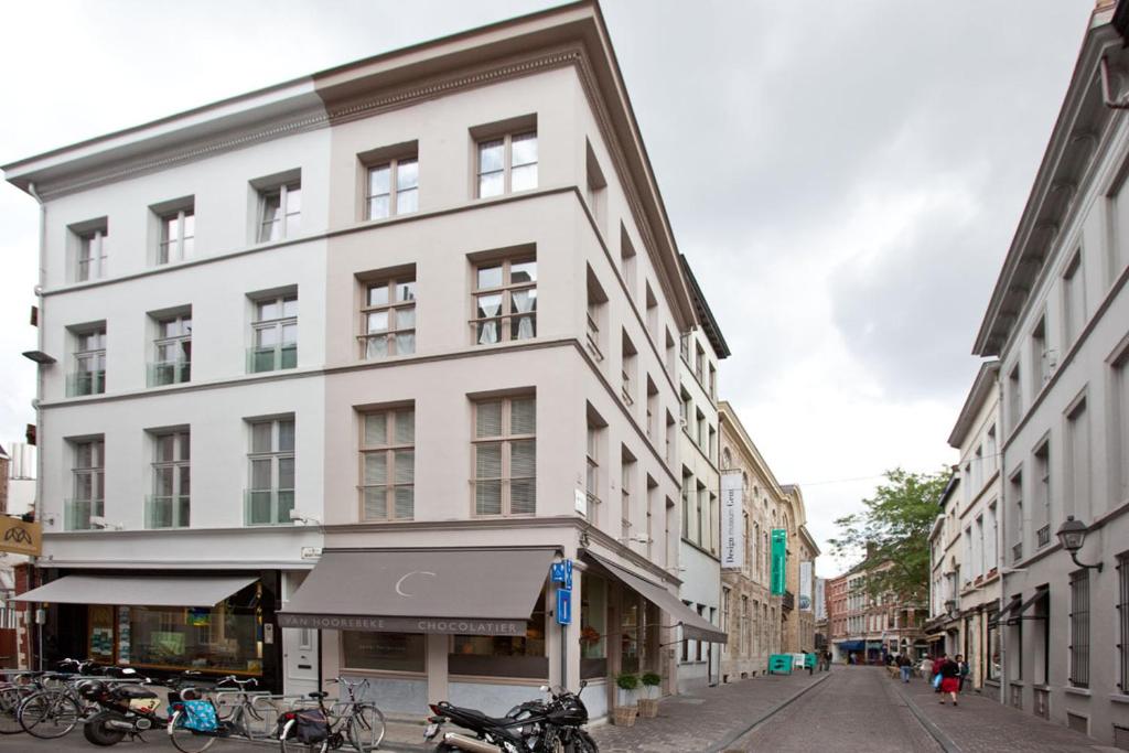 a white building on a street with bikes parked in front of it at Drabstraat 2 Apartment in Ghent