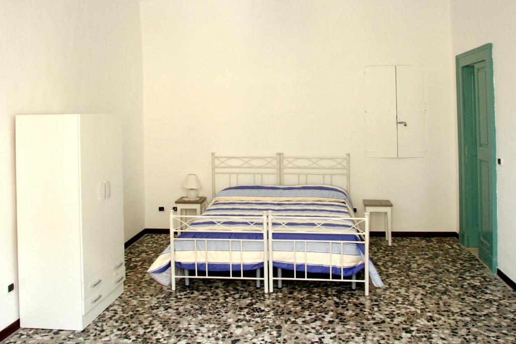 カザラーノにあるPalazzo Galloの白いベッドルーム(ベッド1台、テーブル2台付)
