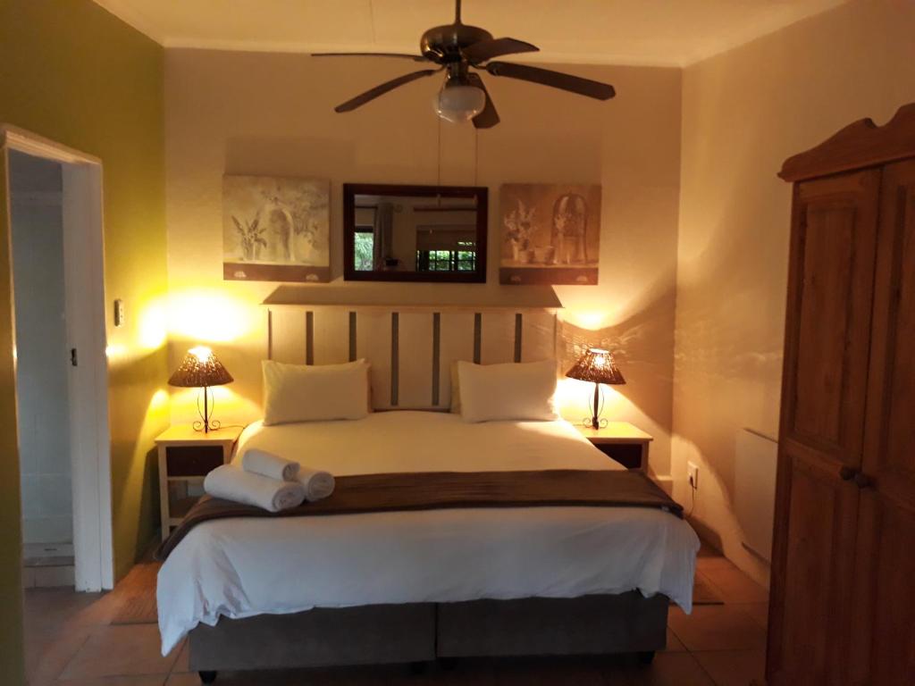 a bedroom with a bed with a ceiling fan at Tourist Lodge Gansbaai in Gansbaai