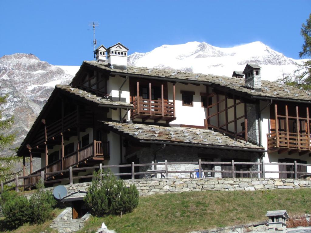 a house in the mountains with snow at Il Piccolo Residence in Gressoney-la-Trinité