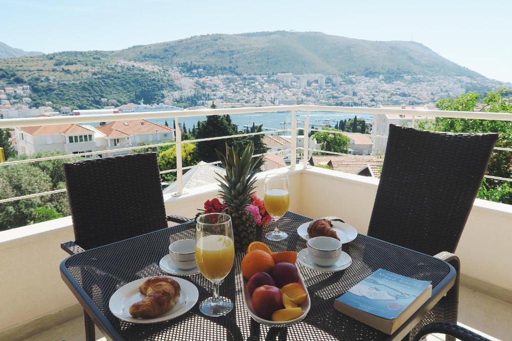a table with food and drinks on a balcony at Sweet Dream 2 in Dubrovnik