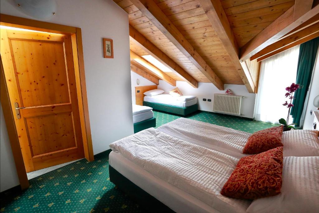 Łóżko lub łóżka w pokoju w obiekcie Alp Hotel Dolomiti